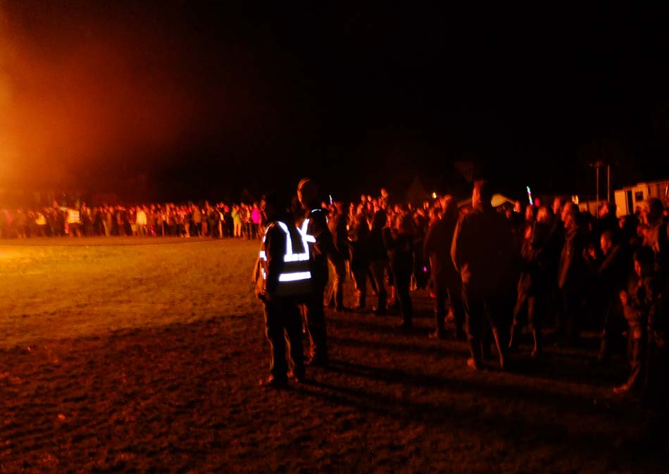 Onlookers at bonfire at night