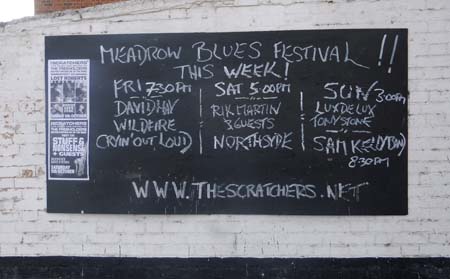 Black board on Outside Wall of The Three Lions Advertising Meadrow Blues Festival and with posters for  The Freeholders